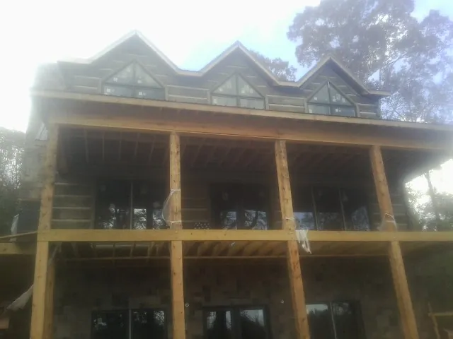 Dormers and porch framing on a large log home under construction — Roof Coating work by our crew in West Rutland