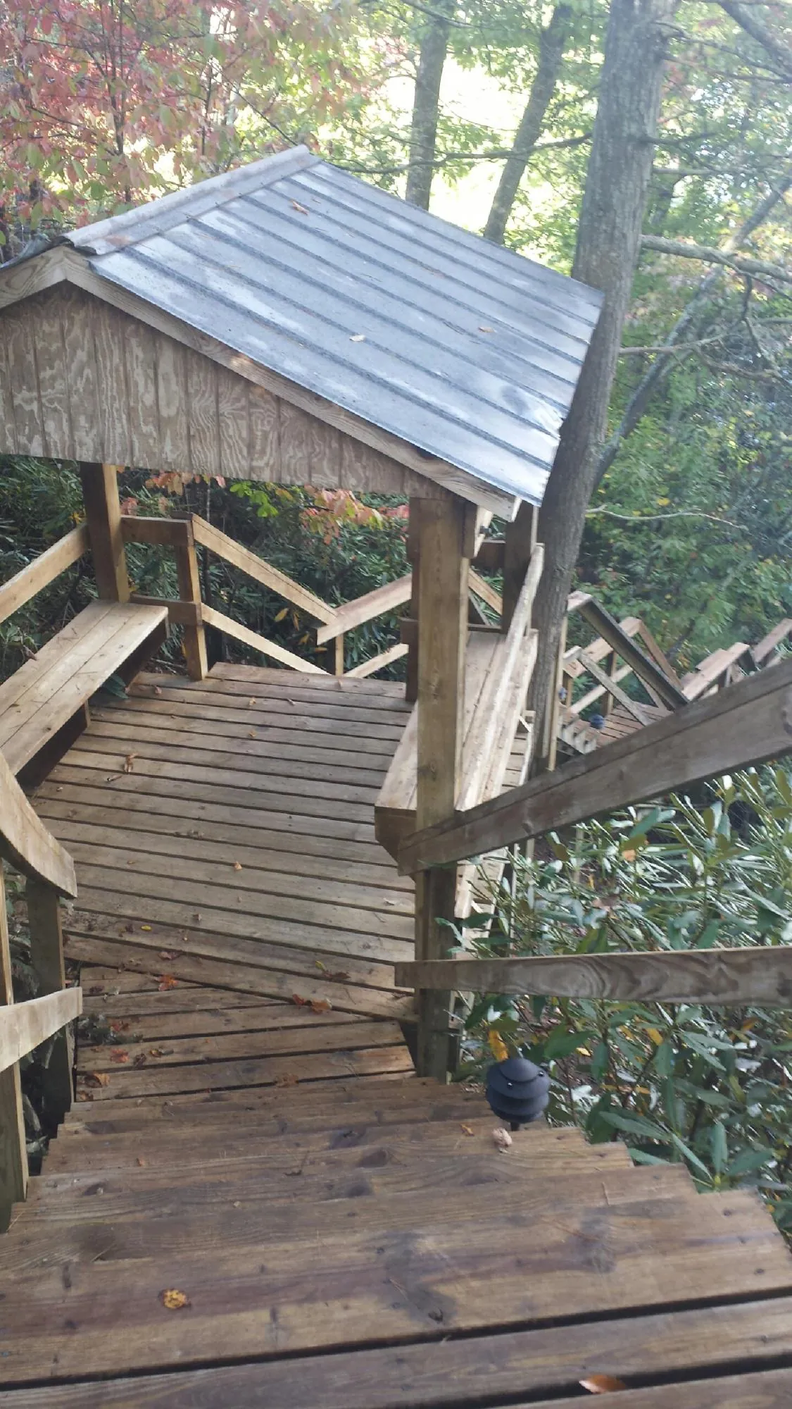 Metal roofed shelter over wooden steps on a wooded walkway — Skylight Repair & Installation work by our crew in West Rutland