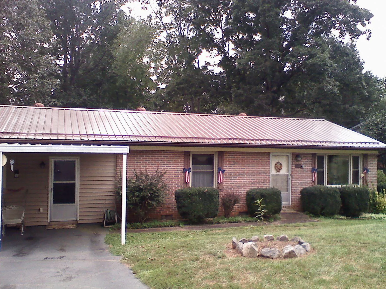 Bronze metal roof and carport on a brick ranch home — Roof Repair work by our crew in West Rutland